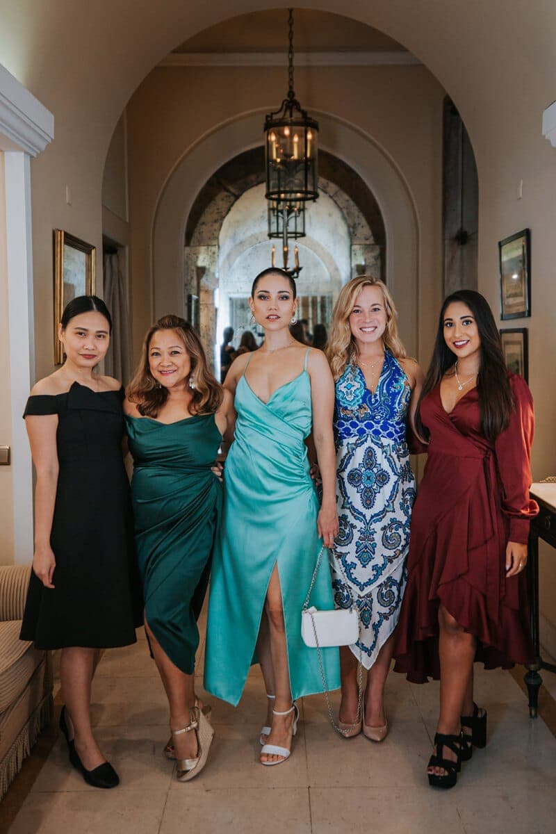 Five delegates in evening dresses in a hotel corridor