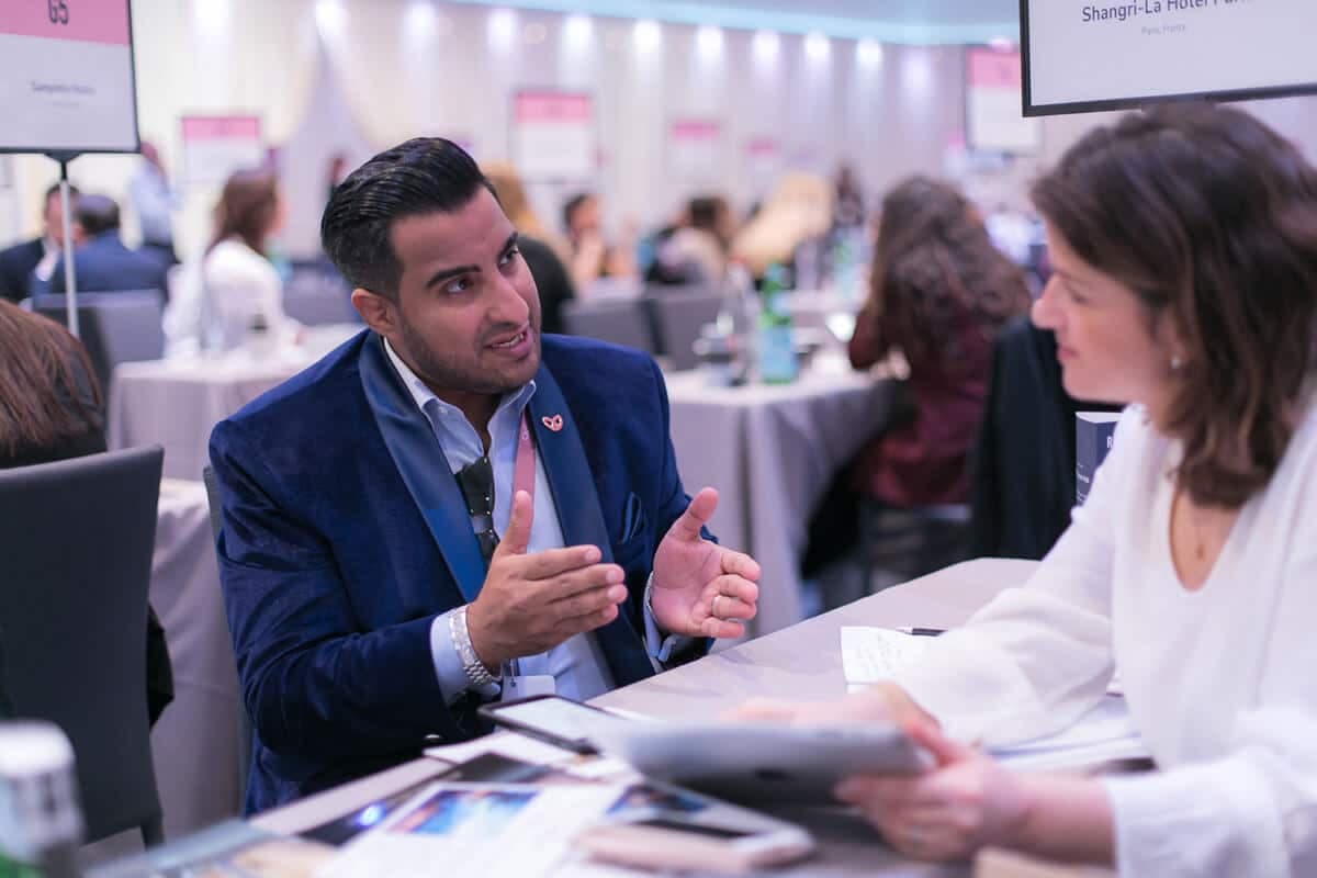 Two delegates in conversation at a meeting table