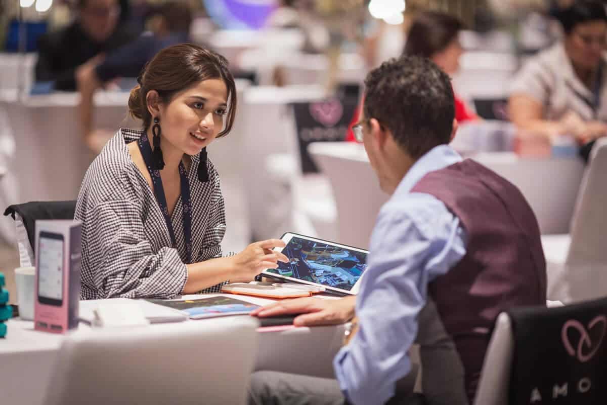 Delegates in a meeting looking at a tablet