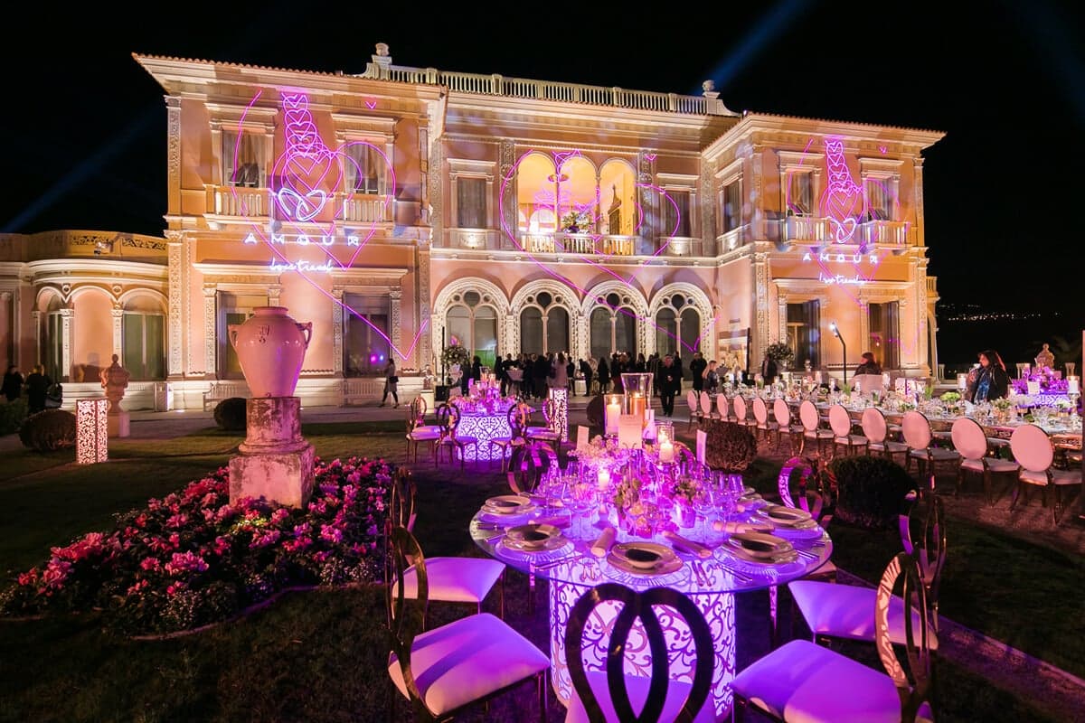 Illuminated palace venue set for an outdoor gala dinner