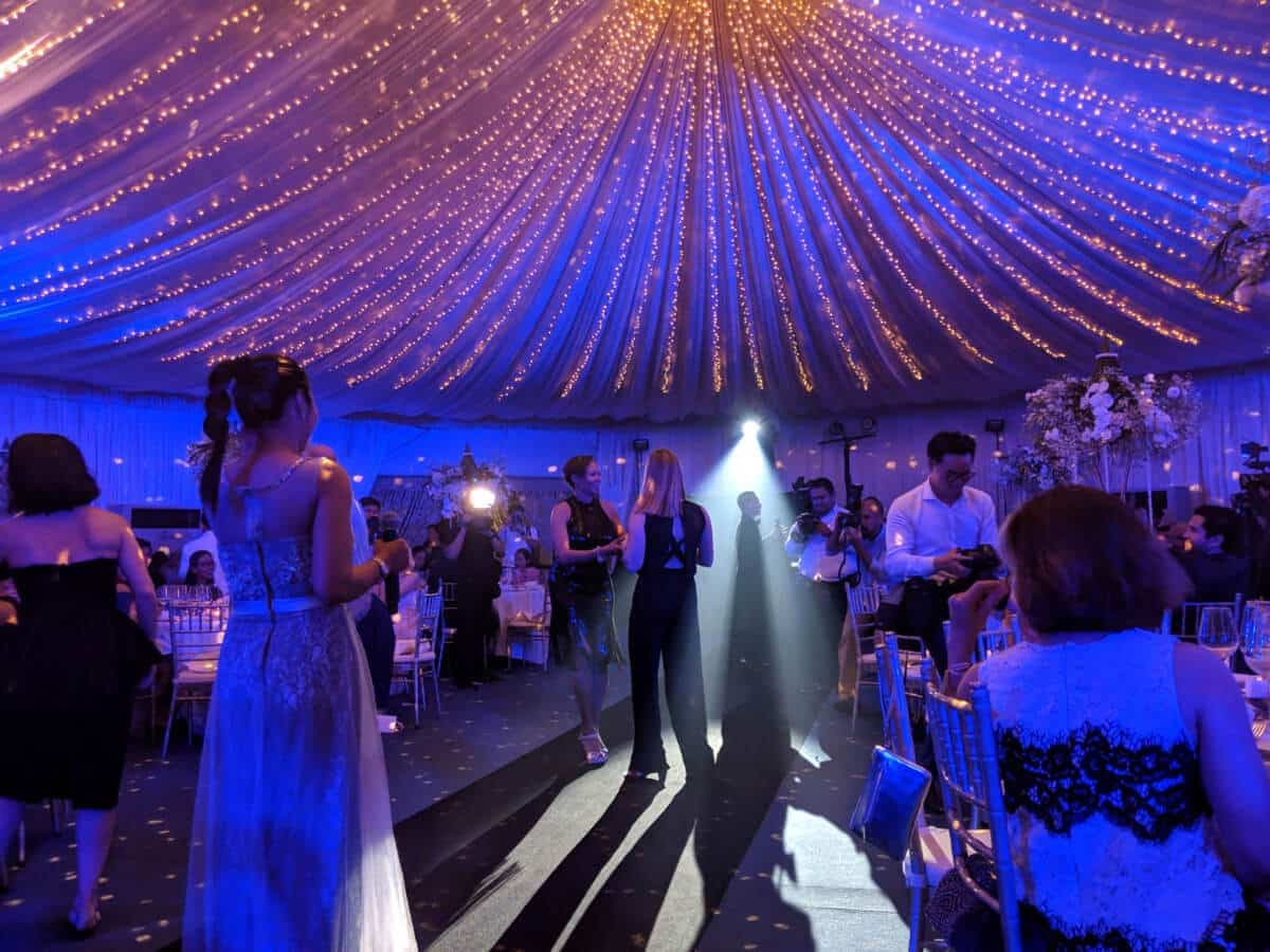 Guests under a canopy of fairy lights at a gala dinner