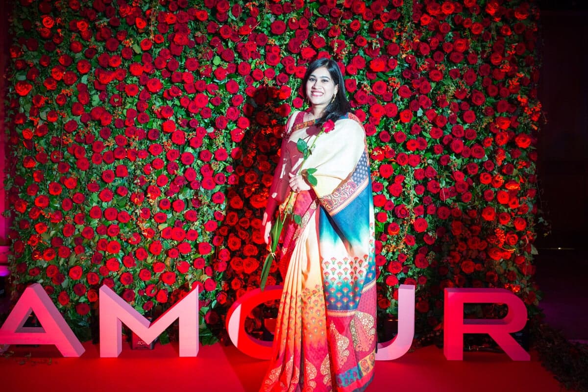 Delegate in a sari at a red rose AMOUR wall