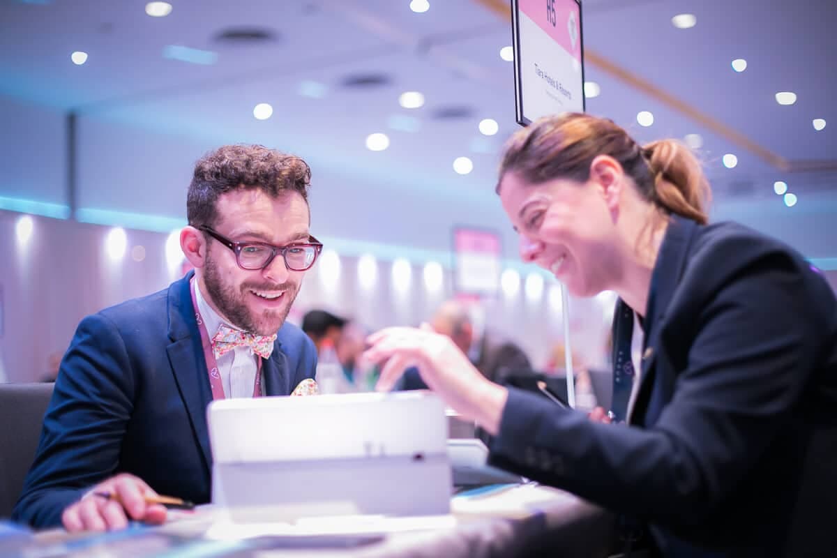 Two delegates laughing during a one-to-one meeting