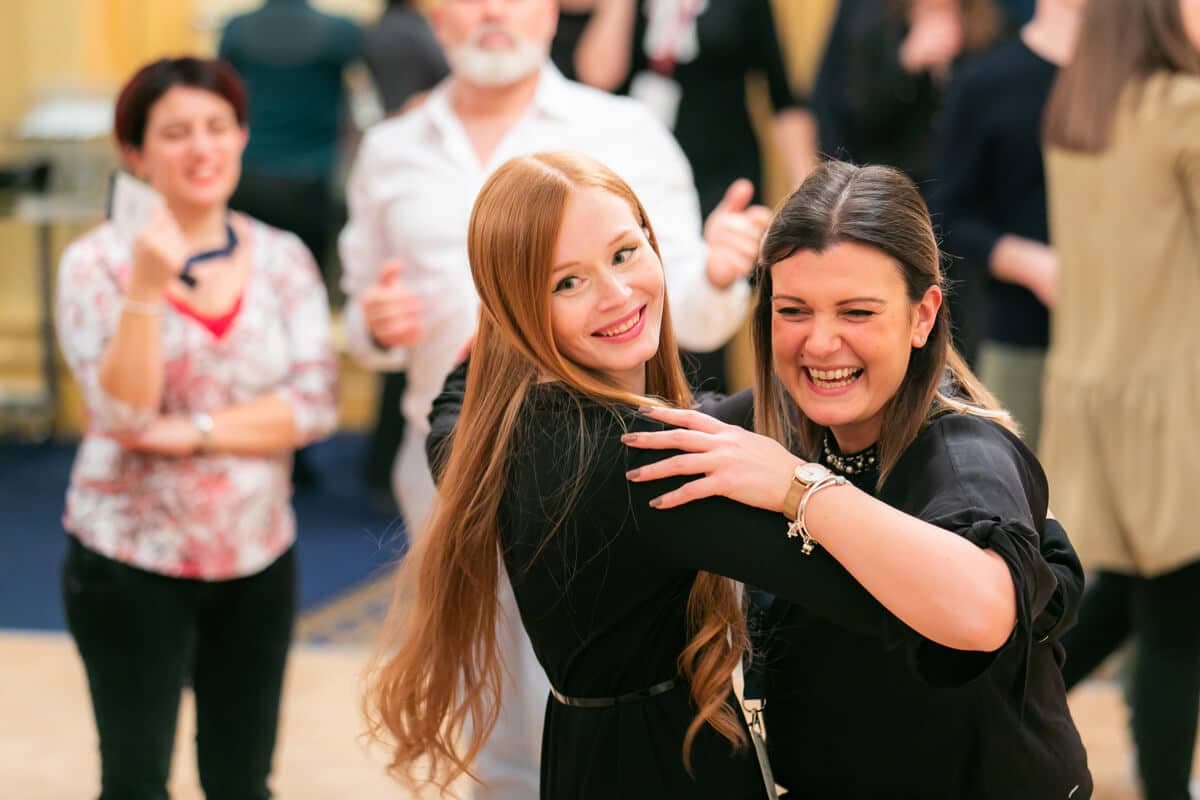 Two delegates dancing and laughing