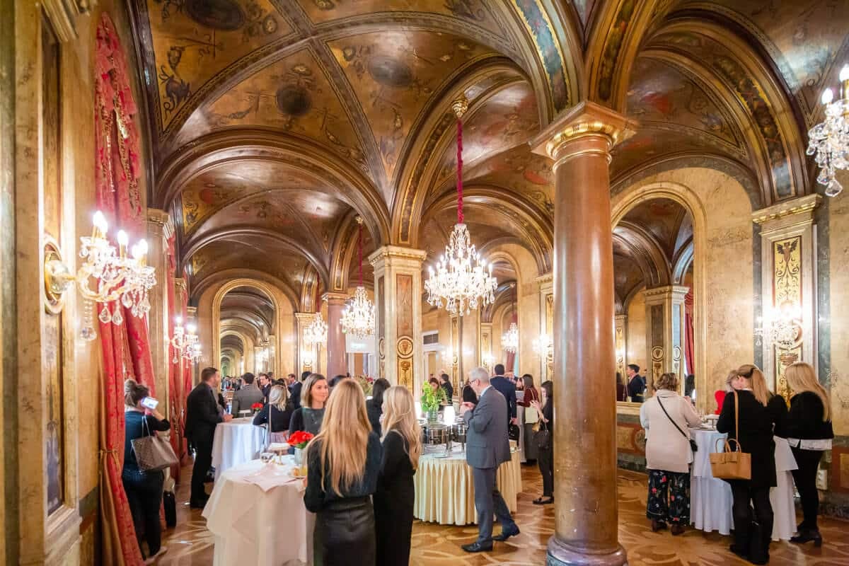 Reception in an ornate hall with chandeliers